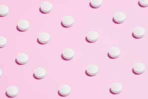 white-round-capsule-on-pink-background-close-up-photography-3683047